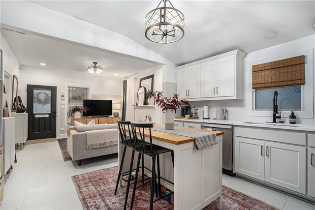 a kitchen with kitchen island granite countertop a sink cabinets and stainless steel appliances