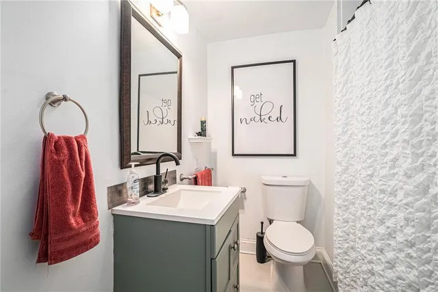 a bathroom with a toilet sink and mirror