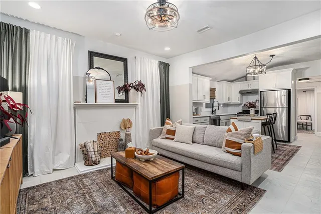 a living room with furniture a rug and kitchen view