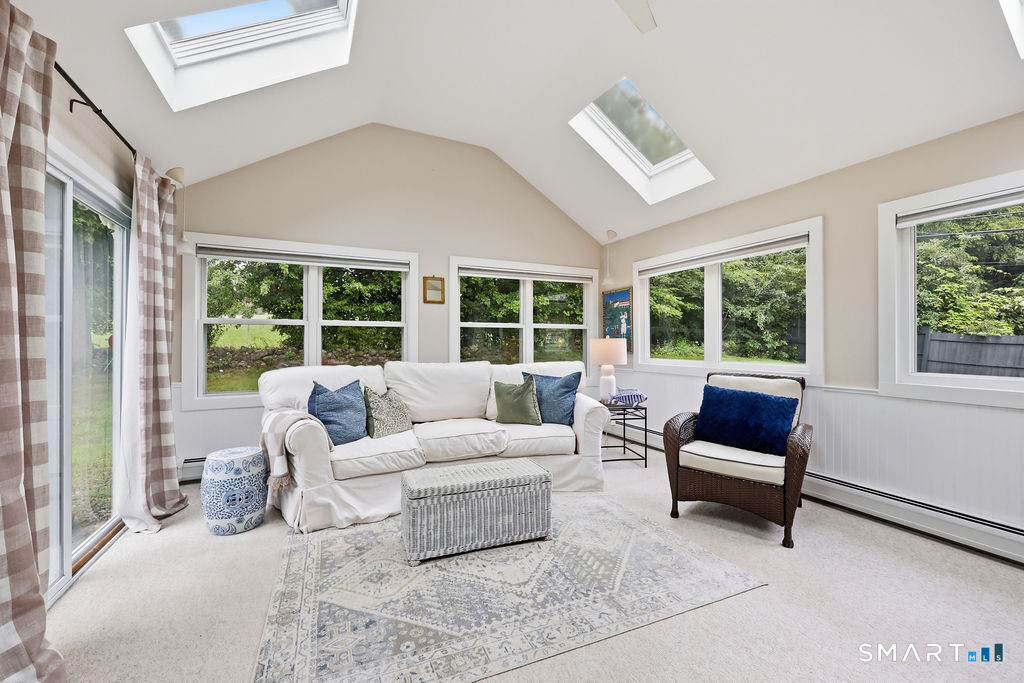 57 Westledge Road Simsbury, CT 06092 - Photo 17 of 34 A sun-filled bonus room offers the perfect blend of comfort and charm, with a vaulted ceiling, skylights, and walls of windows framing peaceful views of the surrounding grounds. This versatile space invites you to curl up with a book, gather with family, or simply enjoy the changing seasons from the comfort of home.