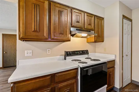 a kitchen with wooden cabinets and a stove top oven