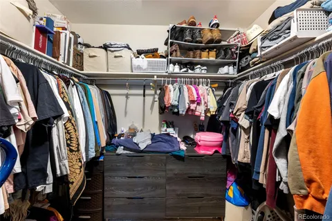 a view of walk in closet with clothes and shoes