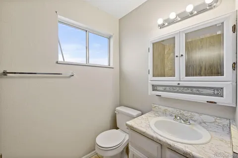 a bathroom with a sink vanity mirror and toilet