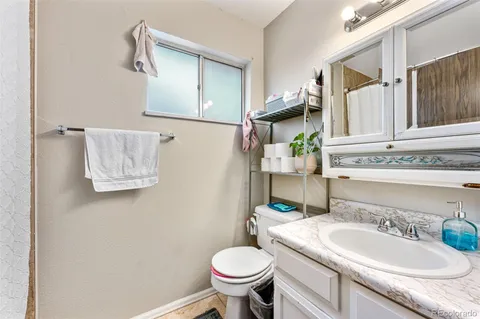 a bathroom with a granite countertop toilet sink and mirror