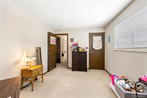 a bed room with a bed mirror and a chair