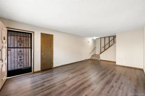 a view of an empty room with wooden floor and entryway