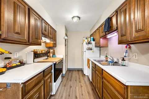 a kitchen with stainless steel appliances granite countertop a refrigerator a sink dishwasher stove and oven with wooden cabinets