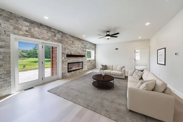 an empty room with windows and ceiling fan
