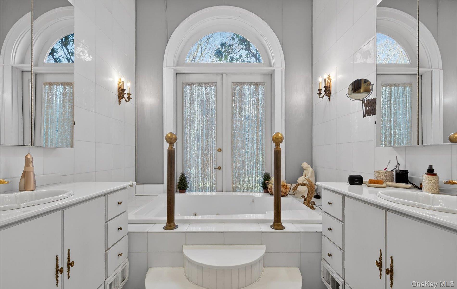 38 Tiffany Road Oyster Bay, NY 11771 - Photo 21 of 50 Full bath featuring two vanities, tile walls, and a garden tub- French door open to view gardens