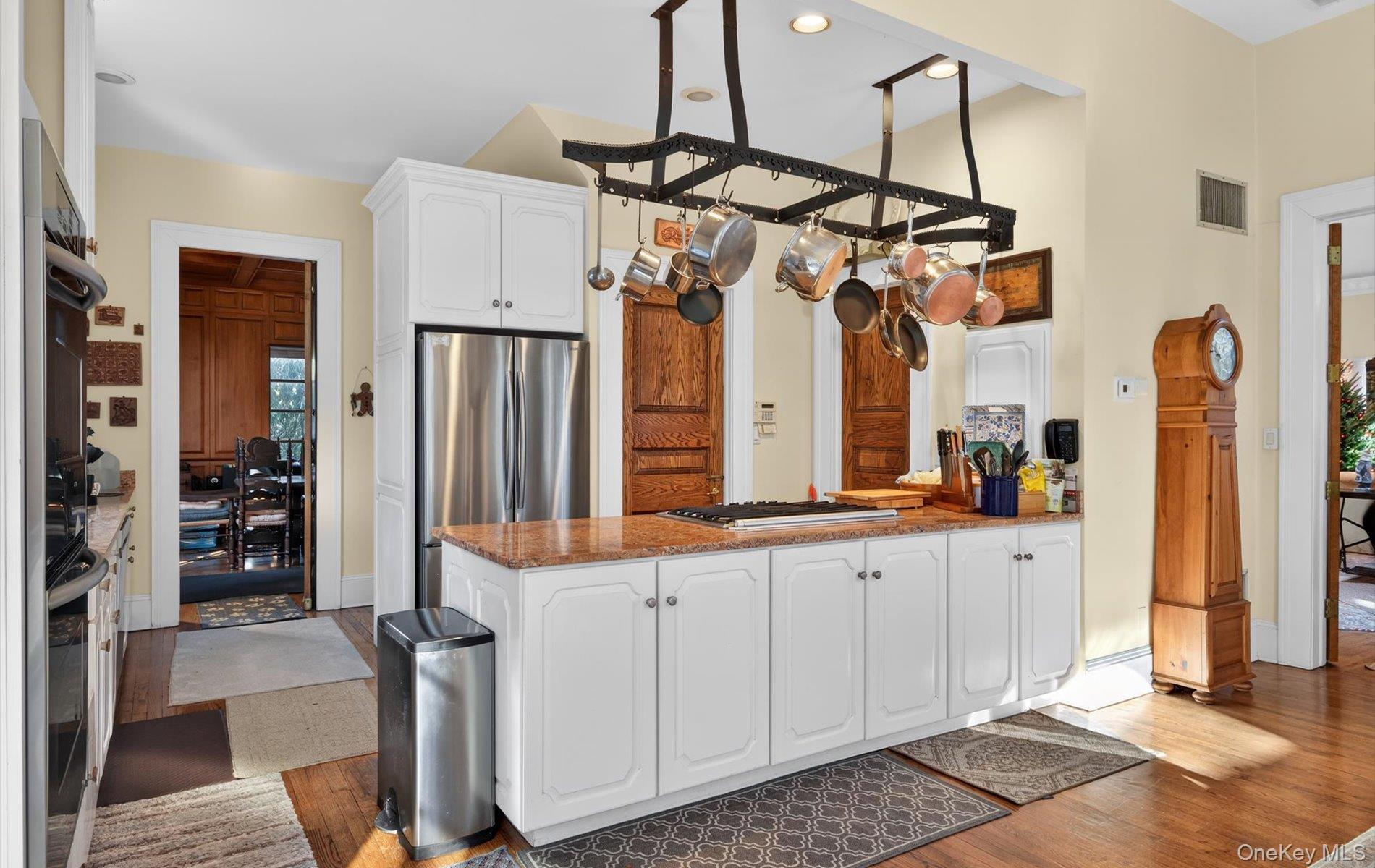 38 Tiffany Road Oyster Bay, NY 11771 - Photo 24 of 50 French country Kitchen featuring a peninsula, white cabinetry, dark stone counters, stainless steel appliances, and light wood-style flooring, large Pantry