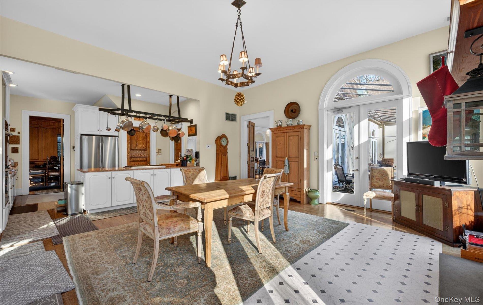 38 Tiffany Road Oyster Bay, NY 11771 - Photo 26 of 50 Farm house styled dramatic kitchen with french doors Dining area with a chandelier and wood finished floors