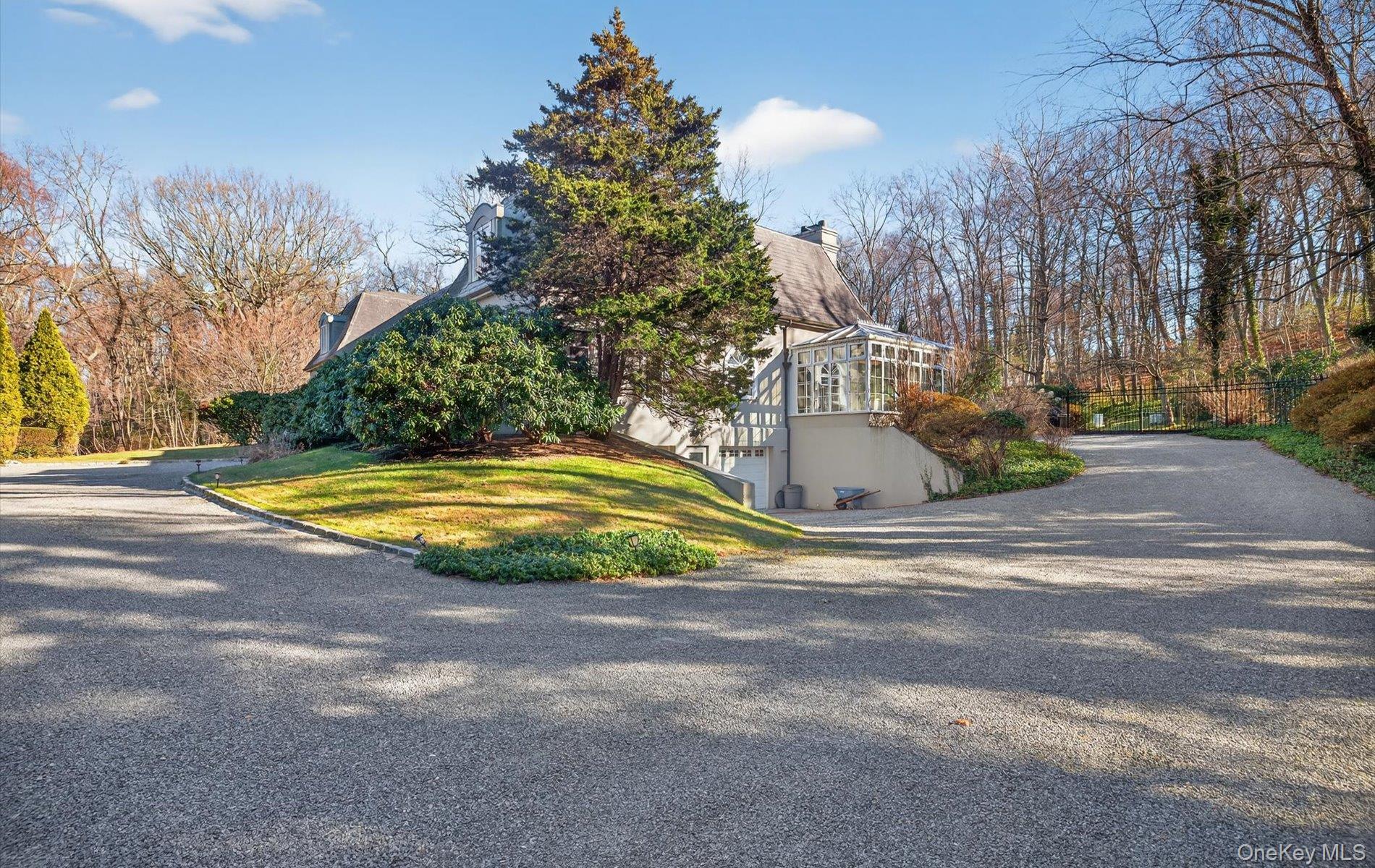 38 Tiffany Road Oyster Bay, NY 11771 - Photo 7 of 50 View of front of property exterior featuring courtyard, speciman trees and gardens