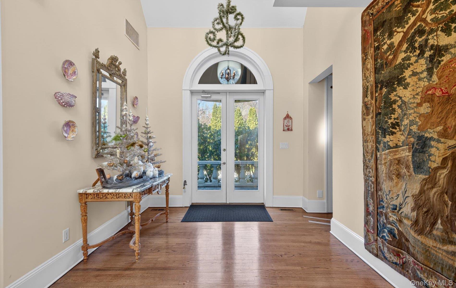 38 Tiffany Road Oyster Bay, NY 11771 - Photo 9 of 50 Entrance foyer featuring french doors, wood finished floors, a high ceiling, and suspended lighting, crown molding