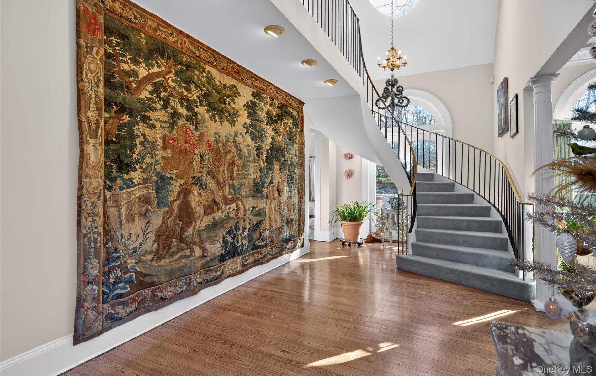 38 Tiffany Road Oyster Bay, NY 11771 - Photo 10 of 50 Entryway featuring a high ceiling, hardwood / wood-style flooring, and suspended lighting, Dramatic Stairway