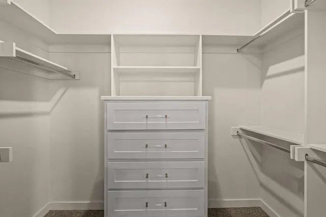 a view of walk in closet with empty racks