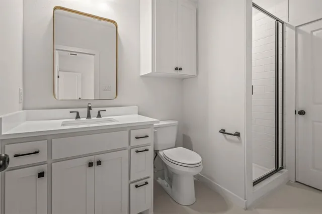 a bathroom with a sink mirror vanity and toilet