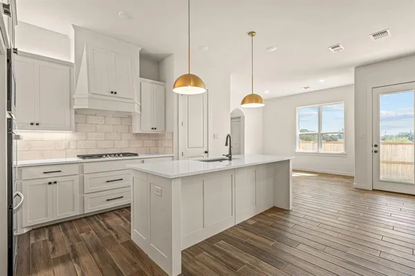 a kitchen with counter top space sink and cabinets