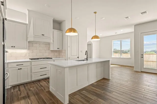 a kitchen with counter top space sink and cabinets