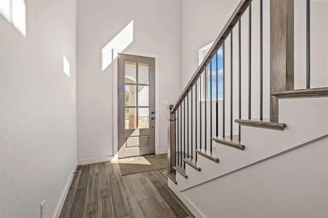 an entryway with wooden floor and staircase