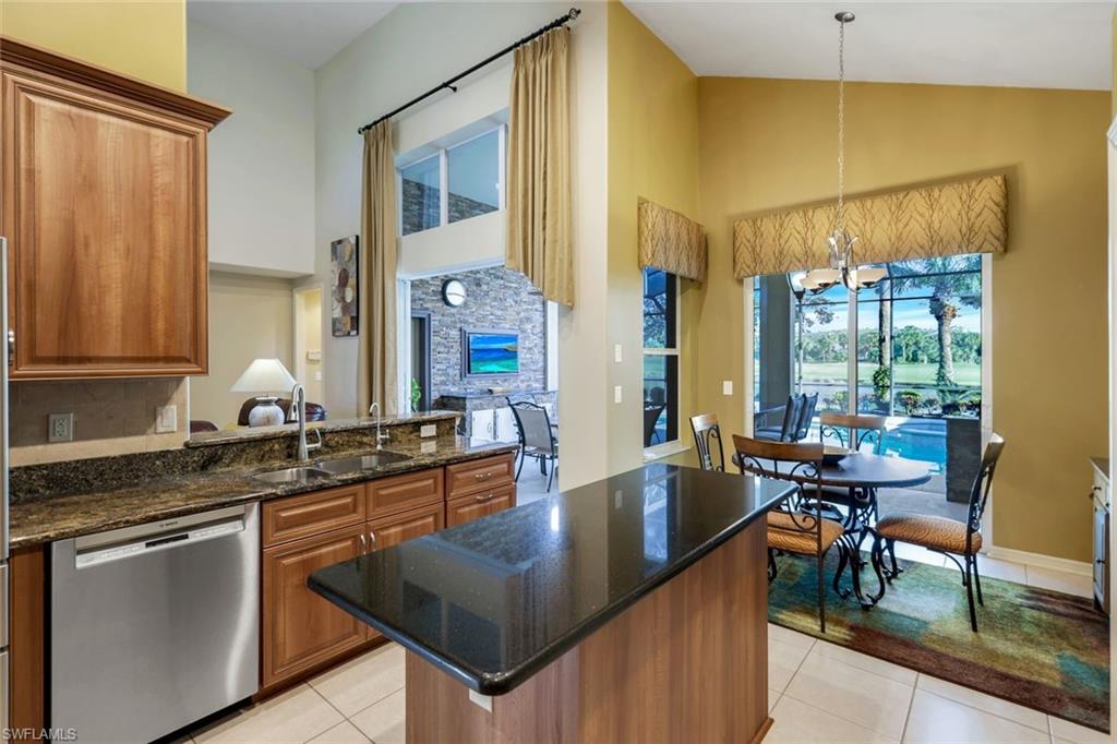 17896 Modena Road Miromar Lakes, FL 33913 - Photo 12 of 38 Updated Island Kitchen featuring stone countertops, stainless steel appliances, overlooking pool, water and golf course.