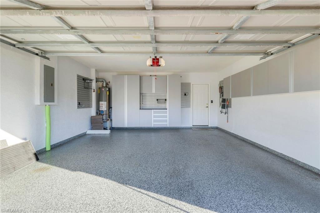 17896 Modena Road Miromar Lakes, FL 33913 - Photo 25 of 38 Garage with Custom storage cabinetry and epoxy finished floor.