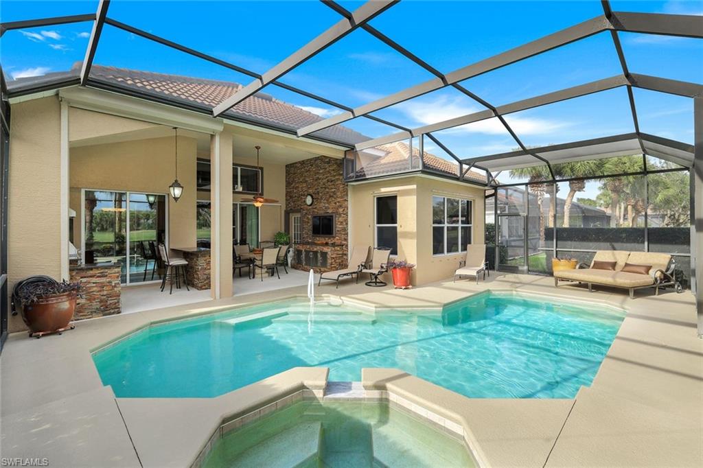 17896 Modena Road Miromar Lakes, FL 33913 - Photo 28 of 38 Furnished pool/lanai viewing outdoor living space, an in ground hot tub, and an outdoor bar.Exclude dining table and chairs. Gas heated pool.