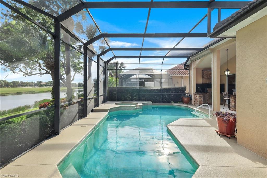 17896 Modena Road Miromar Lakes, FL 33913 - Photo 30 of 38 View of swimming pool with a lanai, a patio, a water view, area for grilling, and an in ground hot tub