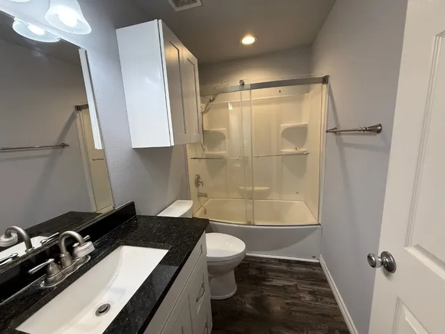 a bathroom with a double vanity sink toilet and shower