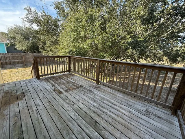 a balcony with wooden floor and trees