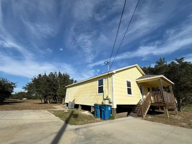 a view of a house with backyard and sitting area