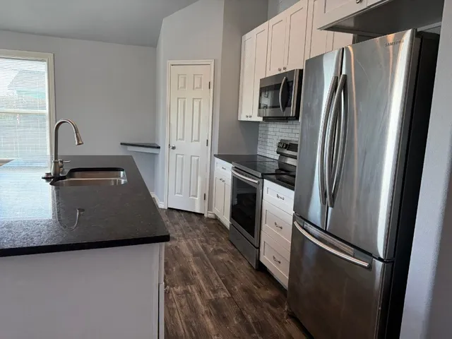 a kitchen with metallic refrigerator and a sink