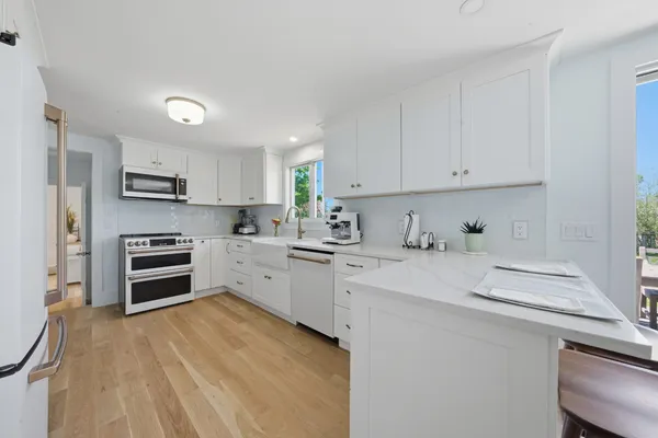 a kitchen with granite countertop a stove sink and cabinets