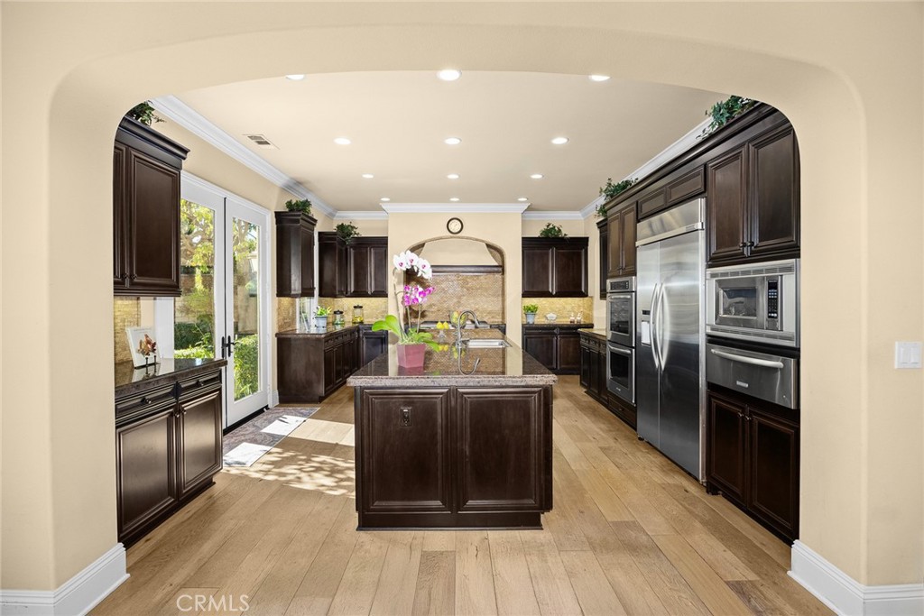 19668 Three Oaks Lane Walnut, CA 91789 - Photo 13 of 45 a kitchen with stainless steel appliances kitchen island granite countertop a refrigerator and a stove top oven