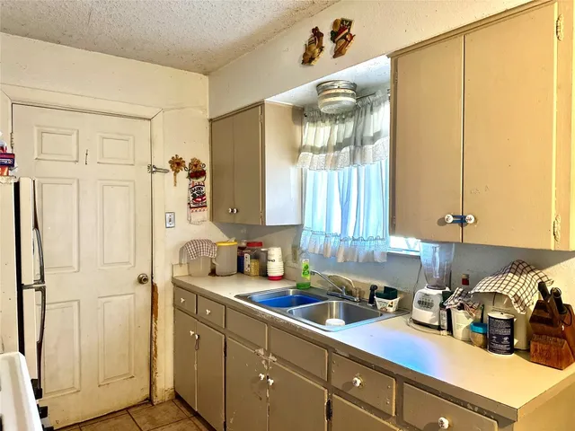 a kitchen with stainless steel appliances a sink a refrigerator and cabinets