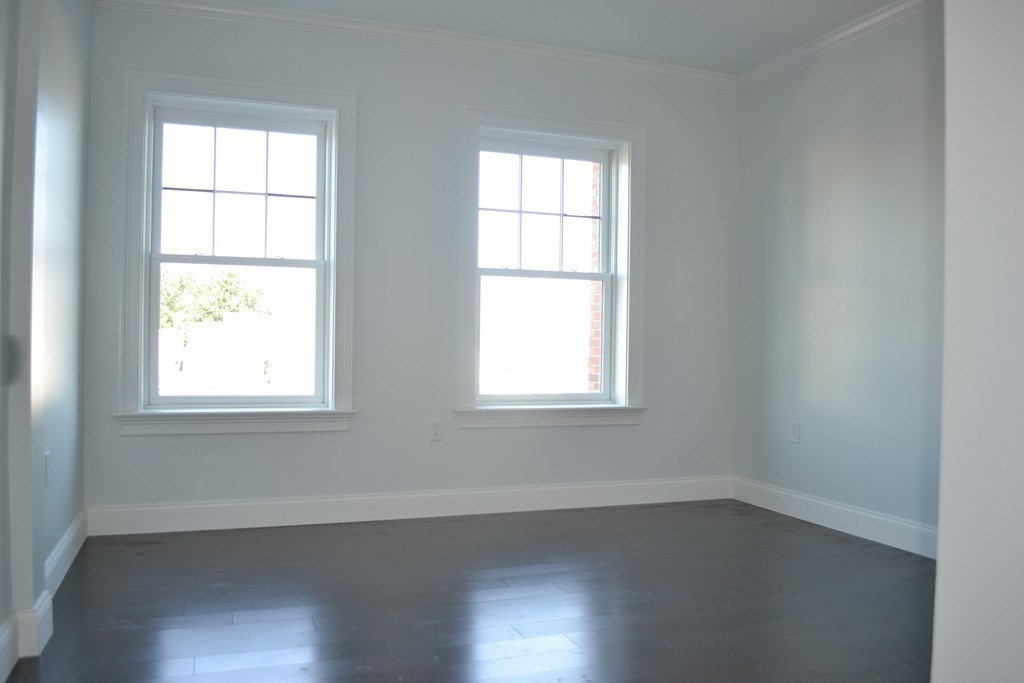 728 East Broadway, Unit 404 Boston, MA 02127 - Photo 8 of 10 an empty room with wooden floor and windows