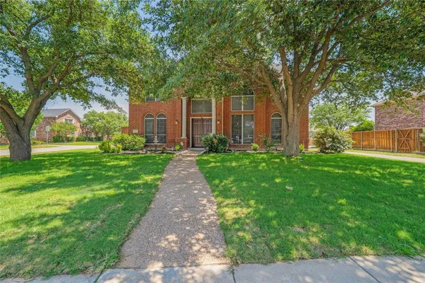 a front view of a house with yard and green space