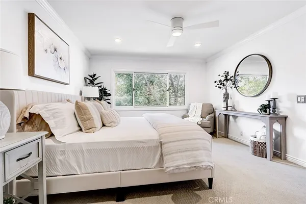 a bedroom with a bed mirror and window