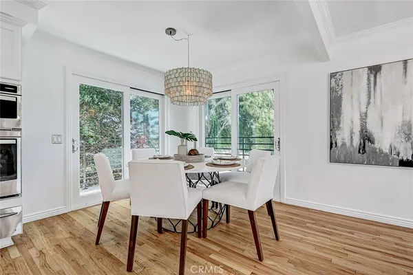 a kitchen with stainless steel appliances granite countertop a refrigerator a stove a sink dishwasher and white cabinets with wooden floor