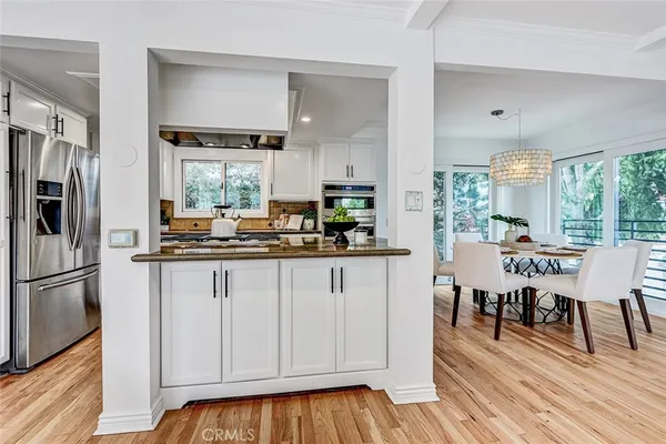 a kitchen with stainless steel appliances granite countertop a sink a stove and cabinets