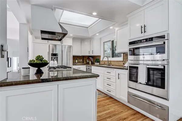 a kitchen with granite countertop a sink appliances cabinets and counter space