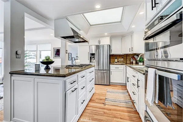a kitchen with granite countertop white cabinets and window