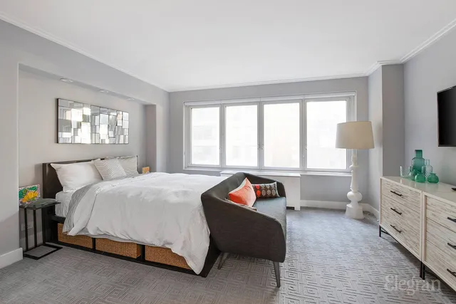 a bedroom with a bed and a large window