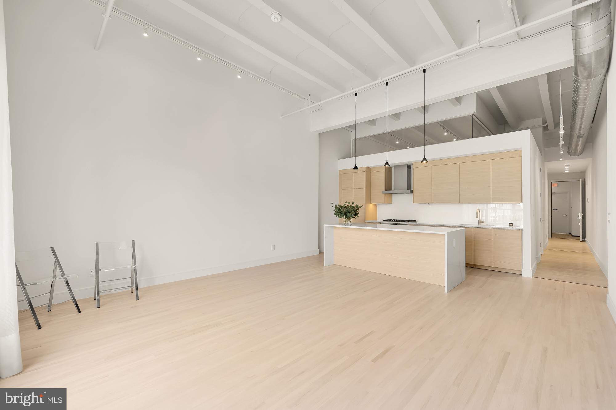 1515 14th Street Northwest, Unit 302 Washington, DC 20005 - Photo 20 of 28 a large white kitchen with cabinets a sink a window and a stainless steel appliances