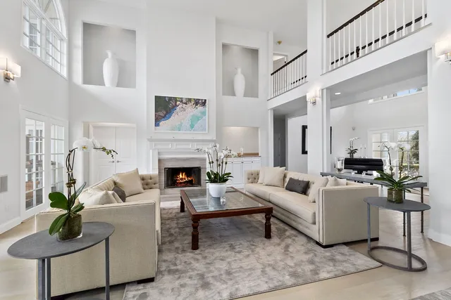 a living room with furniture a fireplace and a chandelier