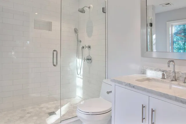 a bathroom with a granite countertop sink toilet and shower