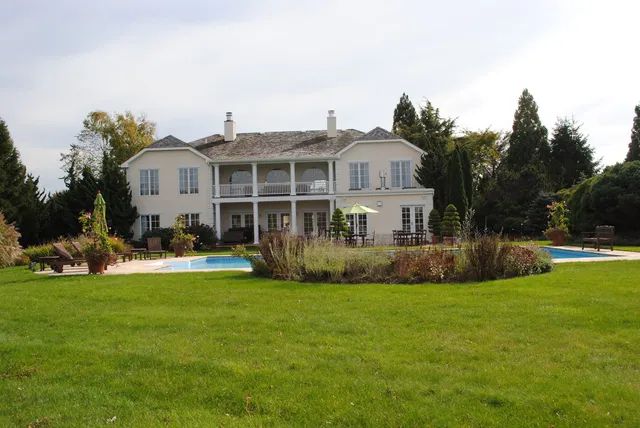 a view of a house with a big yard and potted plants