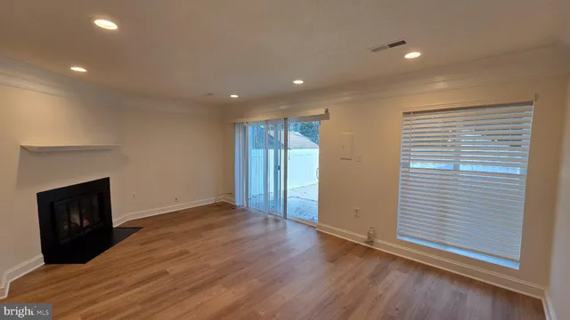 an empty room with wooden floor and fireplace