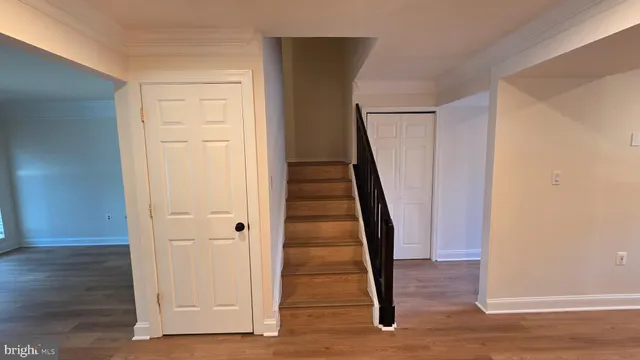 an entryway with wooden floor and staircase