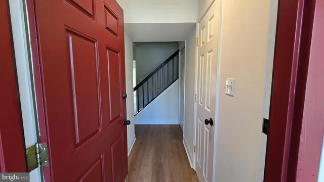 a view of a hallway with wooden floor and staircase