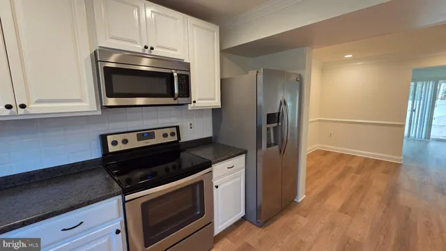 a kitchen with stainless steel appliances a stove microwave and sink